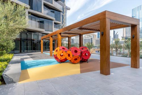 a pavilion with red and orange sculptures on a sidewalk at Address Opera Residences Burj Khalifa View in Dubai