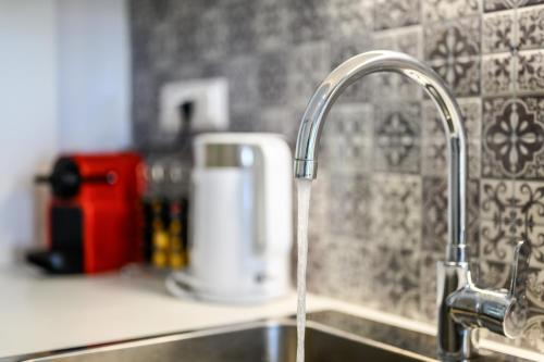 a kitchen sink with a faucet with water coming out at Marillia's elegance residence in Mesaria