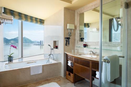 La salle de bains est pourvue d'une baignoire, d'un lavabo et d'une fenêtre. dans l'établissement Shangri-La Wenzhou, à Wenzhou