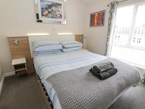 a bedroom with a bed with two black gloves on it at Oyster Bay Lodge in Dalbeattie