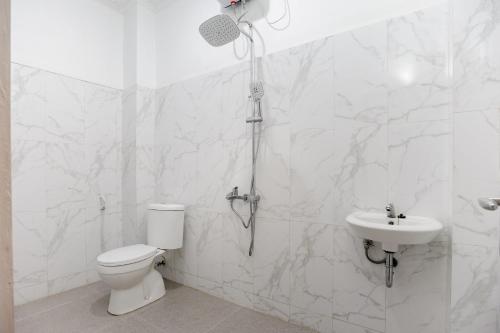 a bathroom with a shower and a toilet and a sink at RedDoorz Syariah @ Sakura Hotel Jatiwaringin in Bekasi
