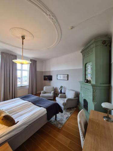 - une chambre avec un grand lit et une cheminée dans l'établissement Hamnhotellet Kronan, à Landskrona