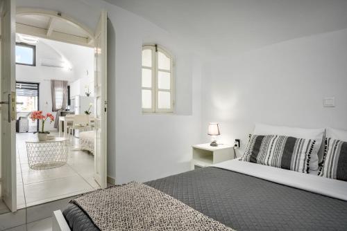 a white bedroom with a bed and a living room at Marillia's elegance residence in Mesaria