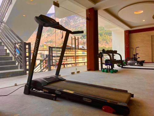 a gym with a treadmill in front of a window at VISTA HOSTEL Near Mall Road Manali - with Playing Zone & Gym in Manāli