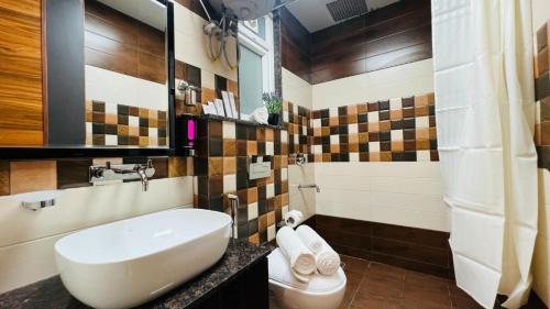 La salle de bains est pourvue d'un lavabo et de toilettes. dans l'établissement ZEN Medicity - Hotel & Serviced Apartments Gurgaon, à Gurgaon