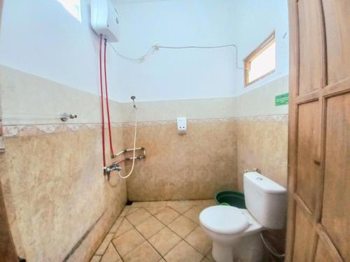 a bathroom with a toilet and a shower at Homestay Jogja Samirono Dekat UNY by Simply Homy in Yogyakarta
