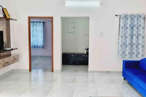 uma sala de estar com um sofá azul e um espelho em Apartment near LNT & CTC & Airport - 3F em Chennai