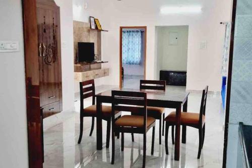 uma sala de jantar com uma mesa preta e cadeiras em Apartment near LNT & CTC & Airport - 3F em Chennai