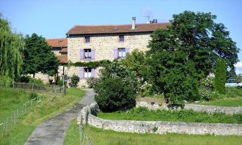 an old stone house with a road in front of it at Gite de l'Elevage de la Mûre in Saint-Just-Saint-Rambert