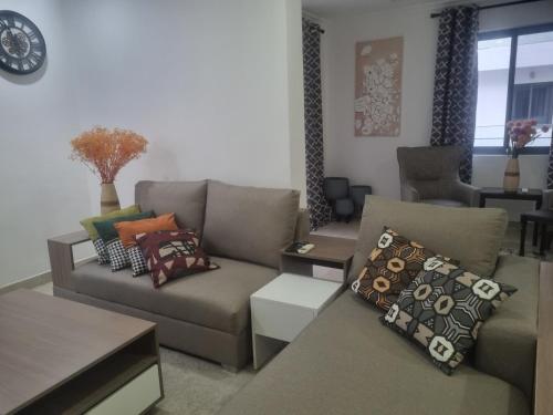 a living room with a couch with pillows on it at Stay Play Away Residences - Luxury 5 bed, Airport Residential in Accra