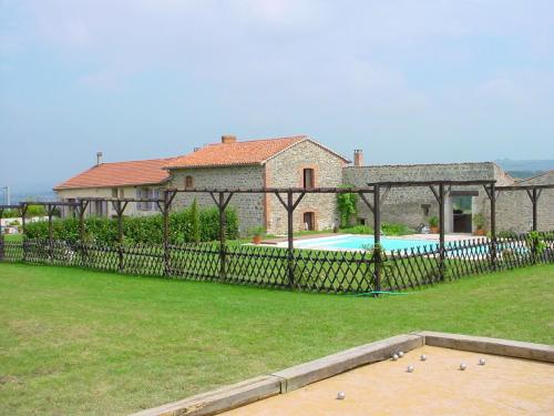 a fence in front of a house with a swimming pool at Gite de l'Elevage de la Mûre in Saint-Just-Saint-Rambert