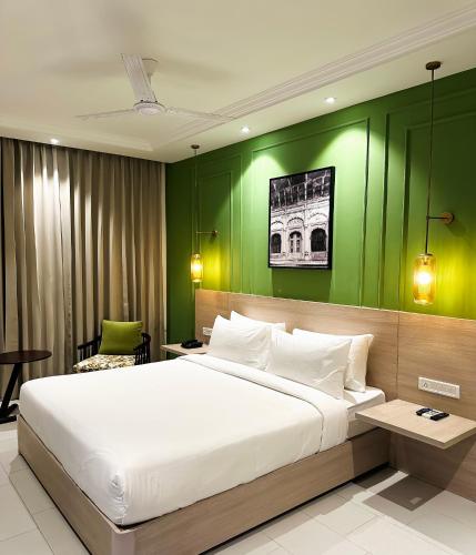 a bedroom with a large bed with a green wall at Hotel Wonder Hills,Har ki Pauri Road Haridwar in Haridwār