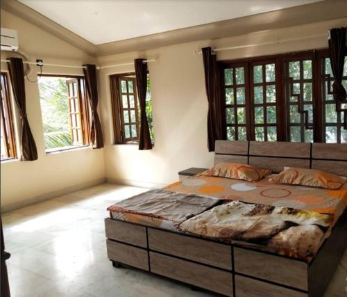 una camera con un grande letto in una stanza con finestre di Water's Edge Villa by 29 Bungalow a Bordi