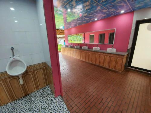 baño con urinario y pared rosa en Ha Giang Garden Bungalow, en Ha Giang