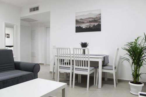 a living room with a table and chairs and a couch at Luxury Suite Apartment #45 By Hashdera Eilat in Eilat