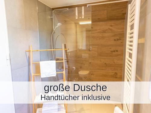 a shower in a bathroom with the words goose cluster handulator inclusive at Ferienwohnung Rambold Sonnenterrasse in Garmisch-Partenkirchen