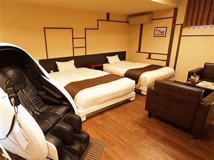 um quarto de hotel com duas camas e um sofá em スパホテル　ティーズリゾート伊勢崎 em Nishi-kunisada