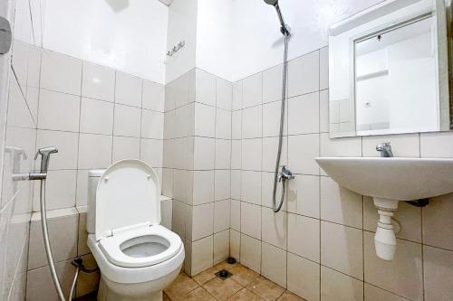 a bathroom with a toilet and a sink at Apartemen Riverview Cikarang by Room PDL 99 in Bekasi