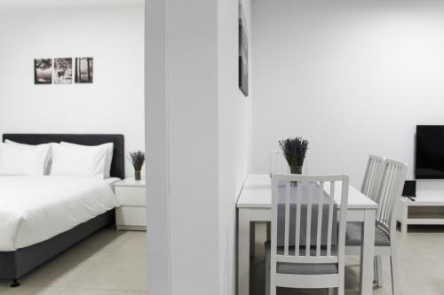 a bedroom with a bed and a table and a chair at Luxury Suite Apartment #45 By Hashdera Eilat in Eilat