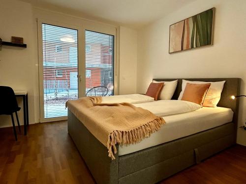 Cama grande en habitación con ventana grande en sHome Apartments Graz - Self-Check-in & free parking, en Graz