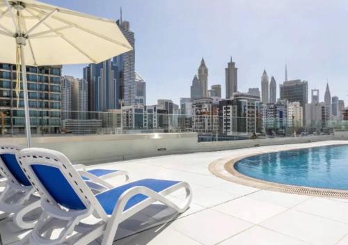 a pair of chairs and an umbrella on the roof of a building at not active in Dubai