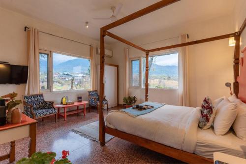 a bedroom with a canopy bed and a living room at Seclude Palampur in Pālampur