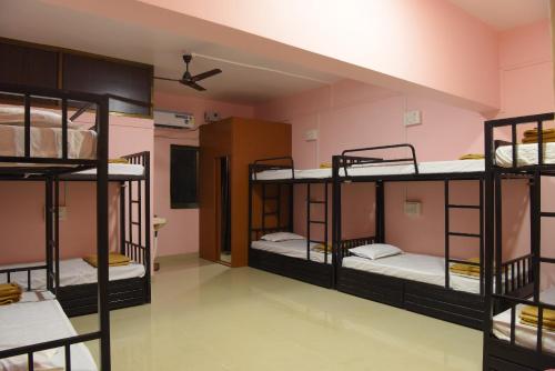 a room with four bunk beds in a dorm at Divers Nest Hostel And Homestays in Malvan