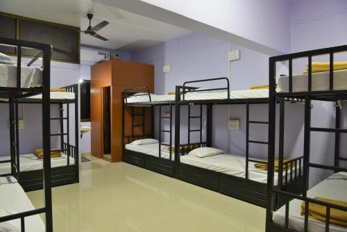 a room with four bunk beds in it at Divers Nest Hostel And Homestays in Malvan