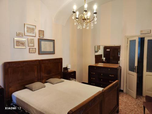 een slaapkamer met een bed, een dressoir en een spiegel bij Sotto la Torre - Under the Tower in Novi Ligure