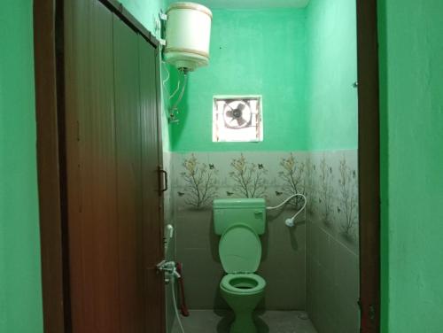 a bathroom with a green toilet in a room at KKA RESIDENCY in Coimbatore