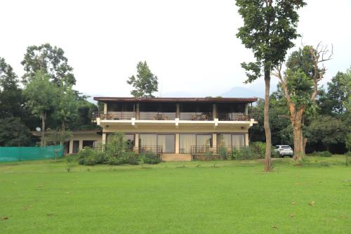 a house with a large yard in front of it at Hideaway By Aahma in Rāmnagar