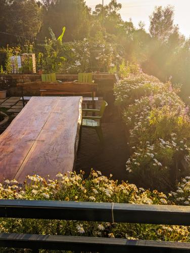 a wooden table and benches in a garden at Cloudwalks Homestay in Kodaikānāl