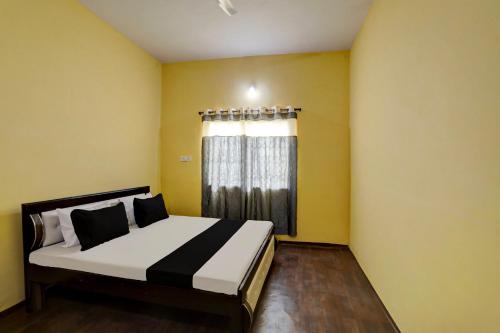 Schlafzimmer mit einem großen Bett und einem Fenster in der Unterkunft SPOT ON City Guest House in Bilāspur