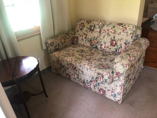 eine Couch in einem Wohnzimmer neben einem Tisch in der Unterkunft Cherbury in Winterton