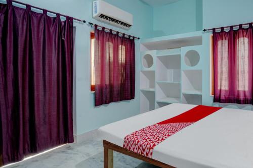 una camera da letto con letto e tende rosse di OYO Flagship Magadh Guest House a Gaya