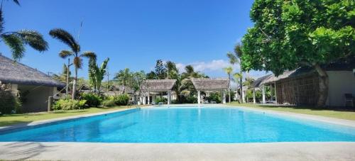 a swimming pool in front of a villa at Ikani Surf Resort in Pagudpud