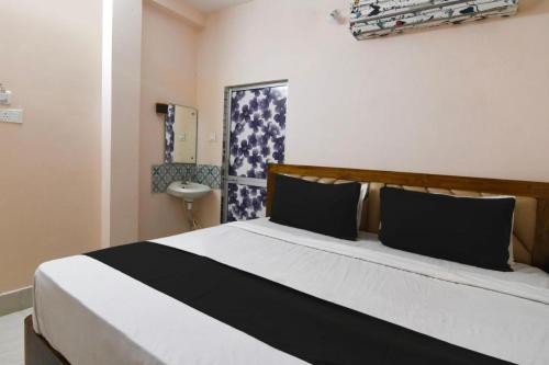 a bedroom with a bed with a black and white comforter at Goroomgo Hasabasa Puri 100 Meter From Beach in Puri