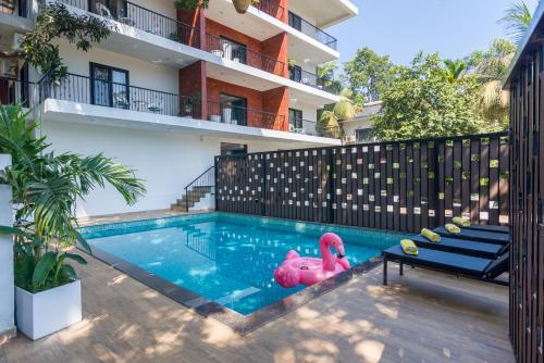 a swimming pool with a pink flamingo in the middle at Etereo Stays, Luxury Premium Apartments, Arpora, Goa in Arpora