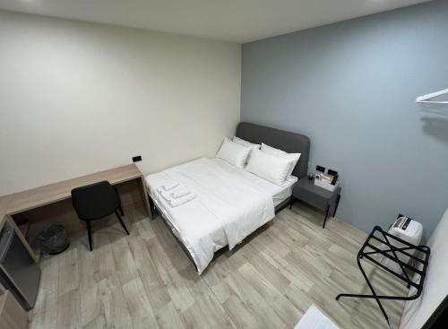 a small bedroom with a bed and a chair at Chill Place ll in Zhudong