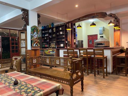 a living room with a table and chairs and a kitchen at Cloudwalks Homestay in Kodaikānāl