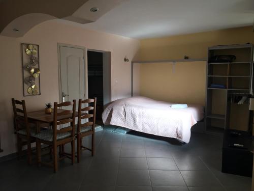 1 dormitorio con 1 cama, mesa y sillas en studio avec terrasse de 20 m2, en Vidauban