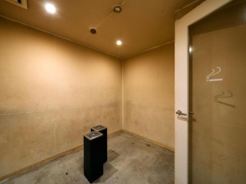 an empty room with a door and a trash can at Hotel Plus Hostel TOKYO KAWASAKI in Kawasaki