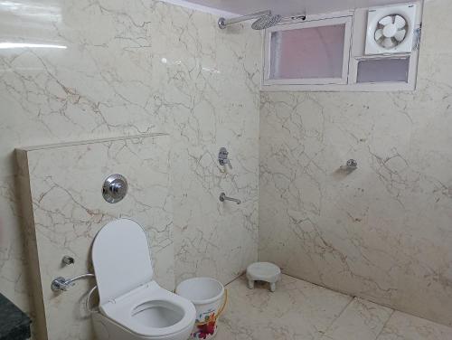 a bathroom with a white toilet and a window at Hotel Airlines in Amritsar