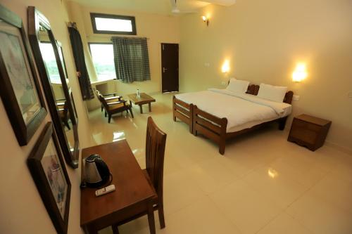 a bedroom with a bed and a table and chairs at Hideaway By Aahma in Rāmnagar