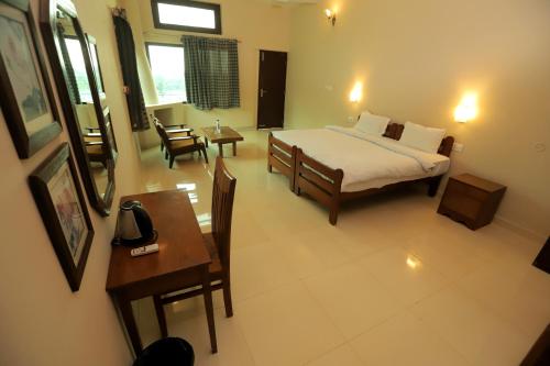 a bedroom with a bed and a table and chairs at Hideaway By Aahma in Rāmnagar