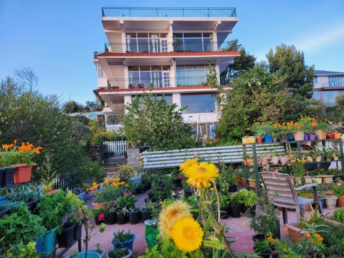 a building with a lot of plants and flowers at Cloudwalks Homestay in Kodaikānāl