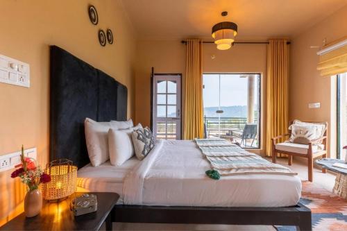 a bedroom with a large bed and a balcony at Seclude Palampur in Pālampur