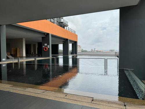 um edifício com uma piscina de água em frente em Summer Escapes em Johor Bahru