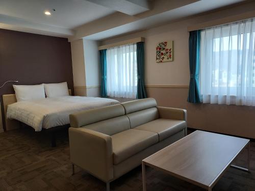 pokój hotelowy z łóżkiem i kanapą w obiekcie Toyoko Inn Changwon w mieście Changwon