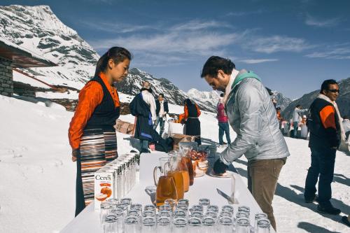 un grupo de personas de pie alrededor de una mesa en la nieve en Mountain Lodges of Nepal - Kongde, en Kongde